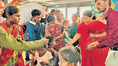 Vijayanagara district Deputy Commissioner Kavitha Mannikeri gives flowers to bonded labourers from Odisha who were rescued from brick kilns.