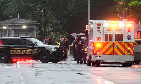 Police and members of the Secret Service stand near an EMS truck after blocking streets around the White House