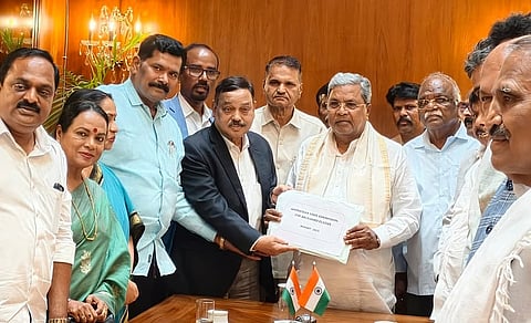 Chairman of the Backward Classes Commission, Madhusudan Nayak, submits the social and educational survey report to CM Siddaramaiah.