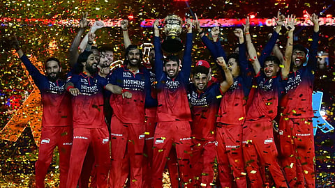 RCB team celebrates with IPL 2026 trophy.