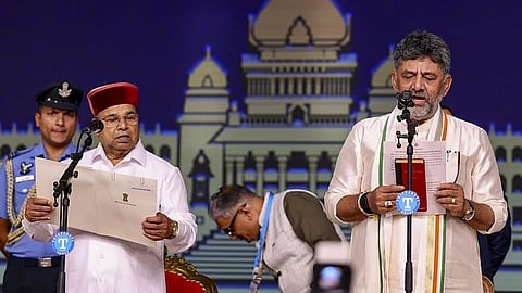 Karnataka Governor Thaawarchand Gehlot, left, administers the oath to state CM-designate DK Shivakumar during the swearing-in ceremony.