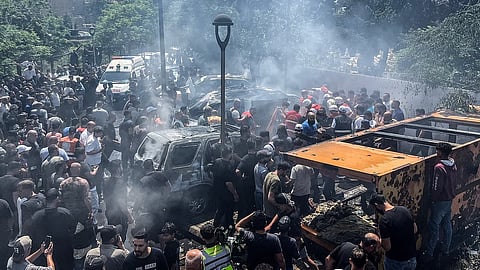 First responders and residents gather at the site of an Israeli airstrike that hit a car in Sidon on June 10, 2026.