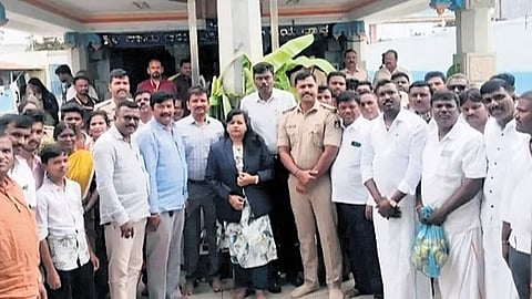 Dalit leaders with Tahsildar CS Poornima and police officials in front of the Anjanaeya Swamy temple at Nidaghatta village in Kadur taluk on Tuesday.