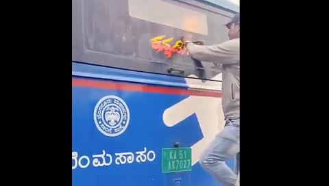 BMTC bus driver remove a "Kannadiga" sticker placed on an electric bus