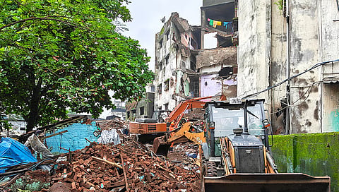 Mud, debris and earthmoving machinery at the site where a portion of the Kohinoor Building 