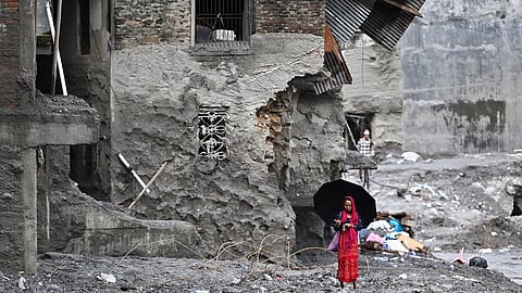 A woman walks among the ruins of flash floods in Nepal's Nuwakot district on September 1, 2026.