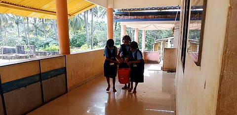 School children brings water in bucket from well 