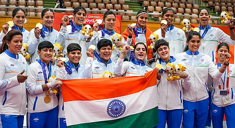 Indian players hold national tricolour flag as they pose for photographs after winning Gold medal in the women's final Kabaddi match against Iran