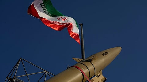 An Iranian missile is displayed under the country's national flag in a military exhibition