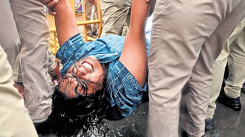 A woman being detained during a protest against SIR exercise outside Town Hall in Bengaluru on Saturday .