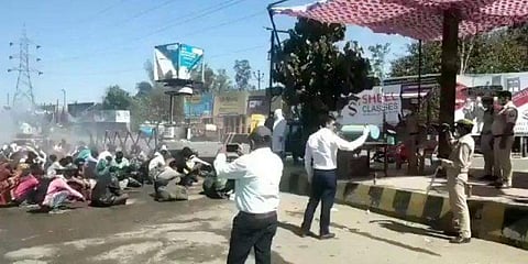 ಕಾರ್ಮಿಕರಿಗೆ ಸ್ಪ್ರೇ ಮಾಡುತ್ತಿರುವುದು