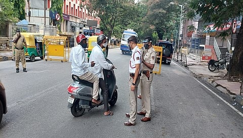 ಬೆಂಗಳೂರಿನ ರಸ್ತೆಯೊಂದರಲ್ಲಿ ಪೊಲೀಸರು ವಾಹನದಲ್ಲಿ ಹೋಗುವವರನ್ನು ವಿಚಾರಿಸುತ್ತಿರುವುದು
