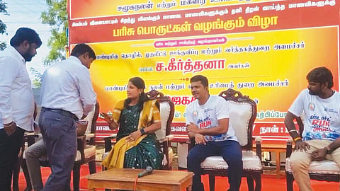 பேனரில் 2-வதாக தனது பெயர் இடம் பெற்றது தொடர்பாக அமைச்சர் ஜெகதீஸ்வரி, கலெக்டர் மற்றும் செய்தி மக்கள் தொடர்பு அதிகாரியிடம் வாக்குவாதம் செய்தார்.