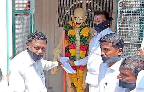 நெல்லை தச்சநல்லூரில் காந்தி சிலையிடம் முன்னாள் மந்தியமந்திரி தனுஷ்கோடி ஆதித்தன் வாயில் கருப்பு துணி கட்டி மனு அளித்த காட்சி.