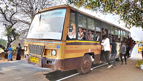 பஸ்சில் தொங்கி செல்லும் பயணிகள்.
