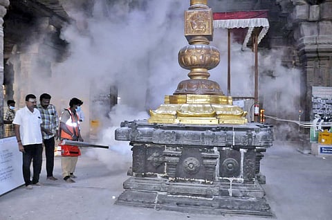 கொடிமரத்தை சுற்றி புகைமருந்து அடித்து சுத்தப்படுத்தும் பணிகள் நடைபெற்ற காட்சி.
