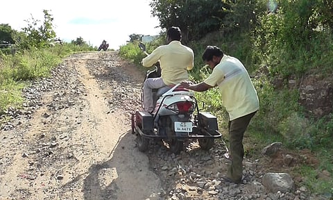 குண்டும் குழியுமாக உள்ள சாலையில் செல்ல சிரமப்படும் மாற்று திறனாளி.