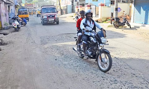 டவுன் பகுதியில் பழுதான சாலையில் செல்லும் வாகன ஓட்டிகளை படத்தில் காணலாம்.
