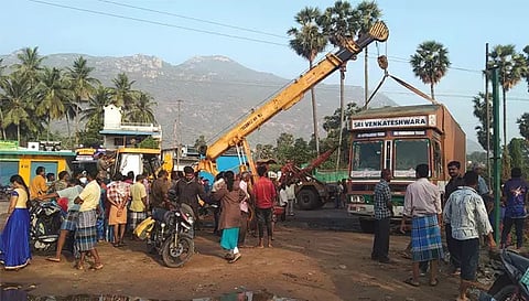 சாலையோர பள்ளத்தில் இறங்கிய கண்டெய்னர் லாரியை கிரேன் மூலம் அப்புறப்படுத்தும் பணி நடைபெற்ற போது எடுத்த படம்.&nbsp;