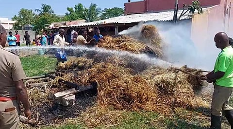 வைக்கோல் போரில் பற்றி எரிந்த தீயை தண்ணீரை பீய்ச்சி தீயணைப்பு வீரர்கள் அணைத்த போது எடுத்தபடம்.