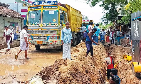 சாலையின் இருபுறமும் பள்ளம் தோண்டப்படும் காட்சி.
