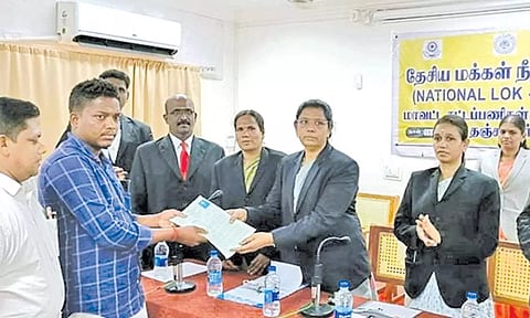 தேசிய மக்கள் நீதிமன்றத்தில் தீர்வு பெற்றவருக்கு தீர்வுக்கான சான்றிதழை வழங்குகிறார் முதன்மை மாவட்ட நீதிபதி ஜெசிந்தா மார்ட்டின்.&nbsp;