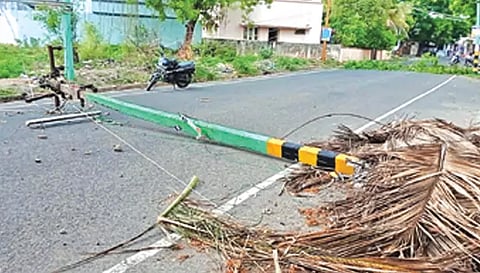 ராசிபுரத்தில் பலத்த காற்று வீசியதால் மின்கம்பம் சாய்ந்து கிடக்கும் காட்சி
