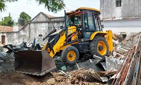 பொக்லைன் இயந்திரம் மூலம் ஆக்கிரமிப்பு நிலம் அகற்றப்பட்ட காட்சி.