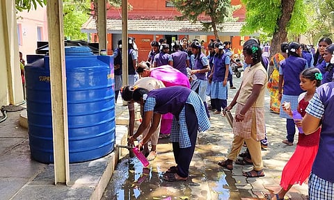 சின்டெக்ஸ் டேங்குகள் மேல் மூடிகள் உடைந்து இருப்பதால் குடிநீரில் அசுத்தம்  இருப்பதையும், அதனை கவனிக்காத மாணவிகள் பாட்டிலில் தண்ணீரை நிரப்புவதையும் படத்தில் காணலாம்.