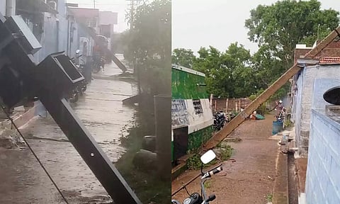 வீடுகள் மீது முறிந்து விழுந்த மின் கம்பங்கள்.