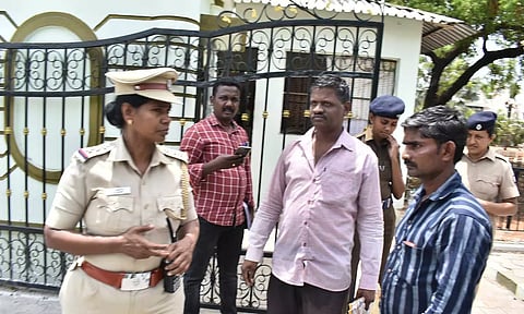 கலெக்டர் அலுவலகம் முன்பு தீக்குளிக்க வந்த நபரை விசாரணை செய்த போலீசார்.

