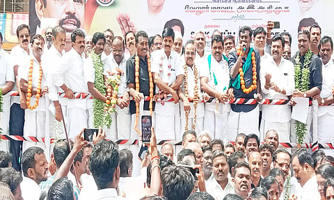 காய்கறிகளை மாலையாக அணிந்து கொண்டு அ.தி.மு.க.வினர் ஆர்பாட்டம் செய்த காட்சி.