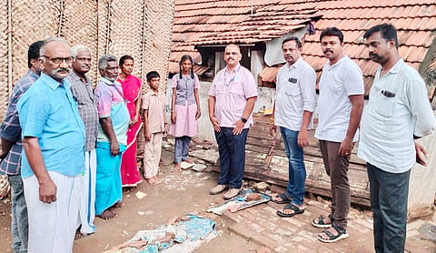 மின்சார இணைப்பு வழங்கப்பட்ட வீட்டின் முன்பு பெற்றோர் மற்றும் ஊழியர்களுடன் மாணவன், மாணவி.
