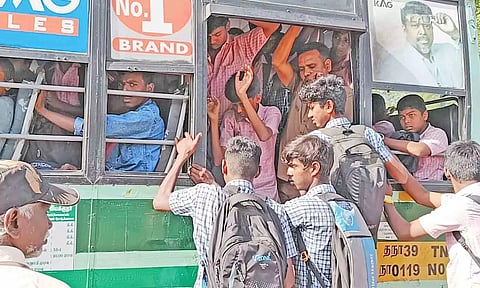 ஆபத்தை உணராமல் பஸ் படிக்கட்டுகளில்  தொங்கியபடி பயணம் செய்யும் மாணவர்களின் காட்சி.