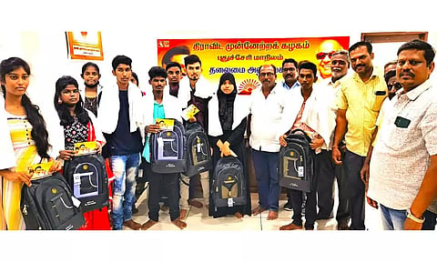 மாணவ-மாணவிகளுக்கு தி.மு.க. பொதுக்குழு உறுப்பினர் கோபால் புத்தகபை பரிசாக வழங்கிய காட்சி.