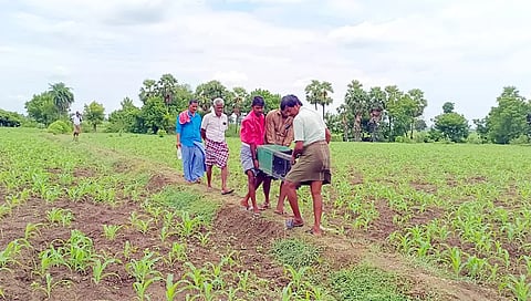 ஓடையில் கிடந்த காலி உண்டியலை கொண்டு வரும் கிராம மக்களை படத்தில் காணலாம்.
