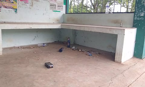நிழற்குடையில் கிடக்கும் குடிமகன்கள் வீசி சென்ற மது பாட்டில்கள்.