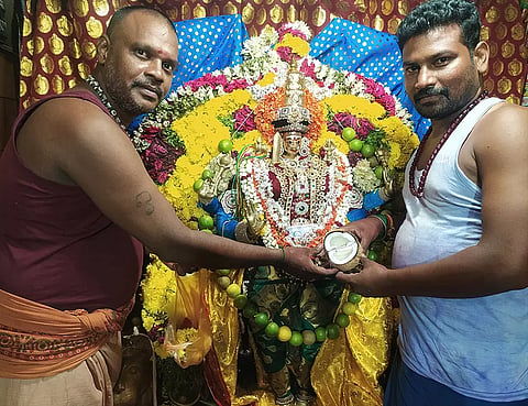 இரட்டை தேங்காயை அம்மனுக்கு பூசாரிகள் காண்பிக்கும் காட்சி.