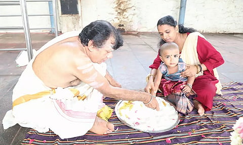 நாகர்கோவில் நாகராஜா கோவிலில் நடந்த வித்யாரம்பம் நிகழ்ச்சியில் அரிசியில் ‘அ’ எழுதும் குழந்தை.