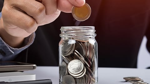 Putting coins in a bottle, fixed deposit concept.