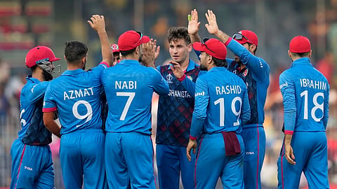 Team mates huddle around Afghanistan teen left arm spinner Noor Ahmed during ICC ODI world cup match against Pakistan in Chennai on October 23, 2023.