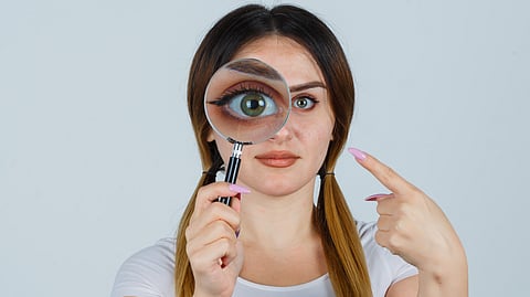 Young woman holding a magnifying glass