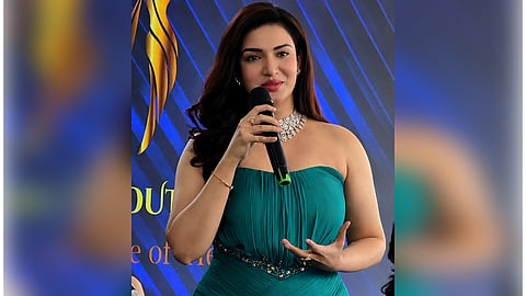 Honey Rose in an emerald green off-shoulder pleated gown