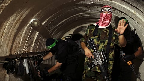 A militant from the Izz al-Din al-Qassam Brigades, the armed wing of the Hamas movement, gestures inside an underground tunnel in Gaza.
