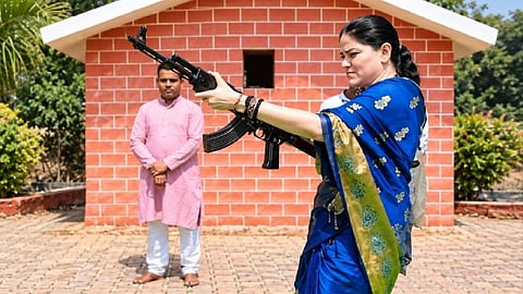 IPS officer Ankita Sharma, wearing a saree and firing an AK-47 rifle.