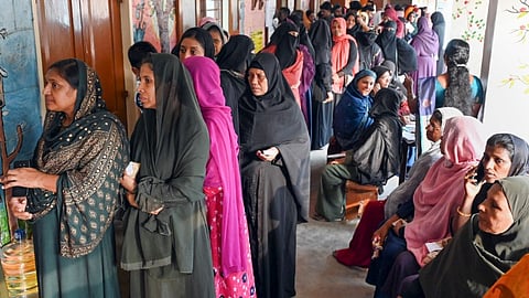 Voters wait in a queue at a polling station to cast their votes during the second phase of Lok Sabha elections, in Thiruvananthapuram, Friday, April 26, 2024.
