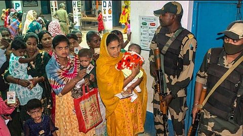 People wait in queues to cast their votes at a polling station during the 3rd phase of Lok Sabha polls, in Malda district, Tuesday, May 7, 2024.