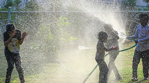 People cool themselves off with water in a park to get relief from the scorching heat on a hot summer day, in Hyderabad, Saturday, May 4, 2024. 