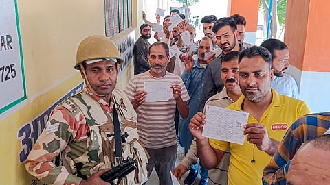 People wait to cast votes at a polling station during sixth phase of Lok Sabha polls, at Dhangri village in Rajouri district, Saturday, May 25, 2024.