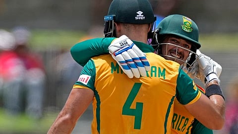 South Africa's captain Aiden Markram, left, and Quinton de Kock celebrate the partnership of 100 runs during the ICC Men's T20 World Cup cricket match between the United States and South Africa at Sir Vivian Richards Stadium in North Sound, Antigua and Barbuda, Wednesday, June 19, 2024. 